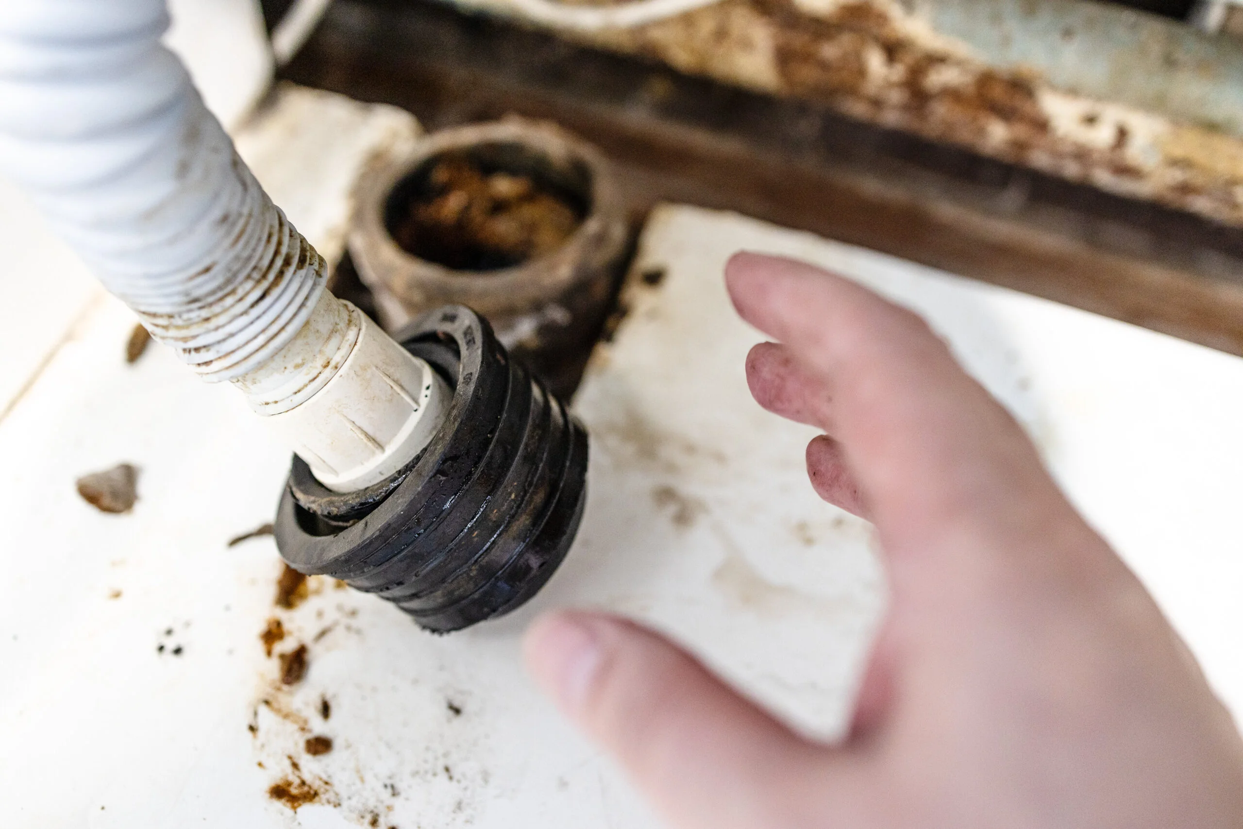 Clogged garbage disposal repair: Close-up of damaged unit and debris.